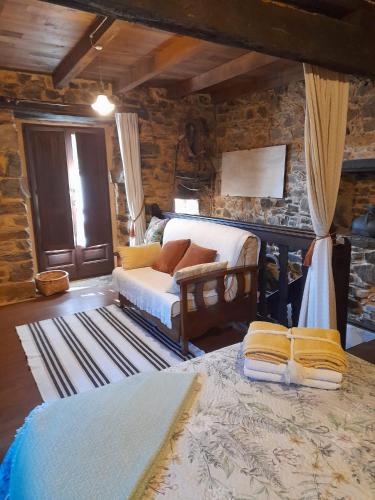 a bedroom with a bed and a couch in a room at Vega in Muñás