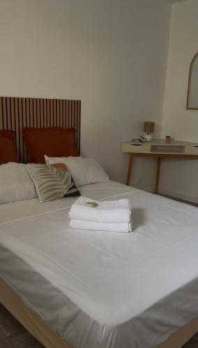 a bed with two white towels on top of it at Appartement Kazalya in Sainte-Rose