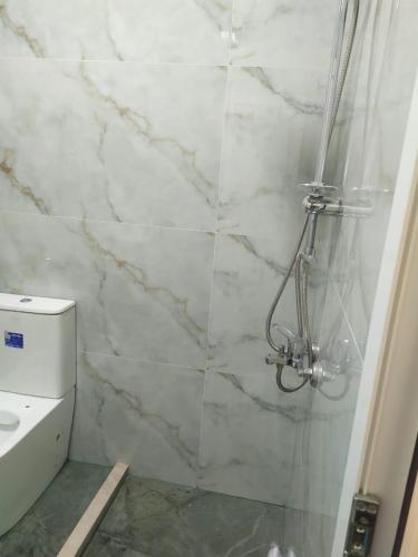 a bathroom with a shower with a marble wall at 2-Room Modern House in Naxçıvan