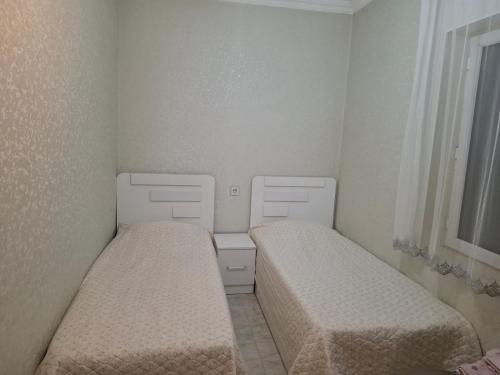a small room with two beds and a window at 2-Room Modern House in Naxçıvan