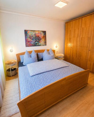 a bedroom with a large wooden bed with blue pillows at Lange Hans Rennsteig in Oberschönau