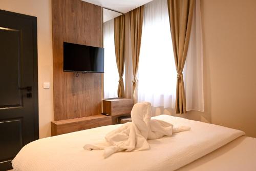 ein Hotelzimmer mit einem Bett, auf dem weiße Handtücher liegen in der Unterkunft Hotel Unca in Jajce