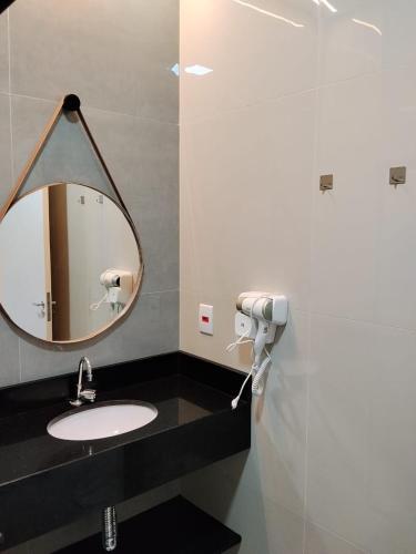 a bathroom with a mirror and a sink at Hotel do Catarina in Rio Bonito