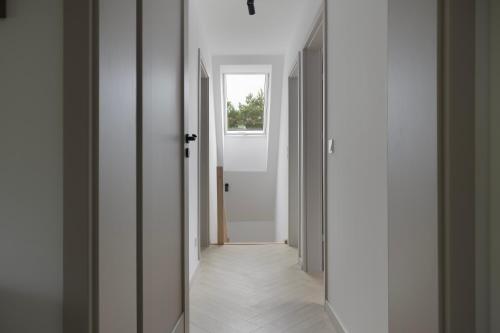a hallway with white walls and a window at Leśne Chwile in Osiek