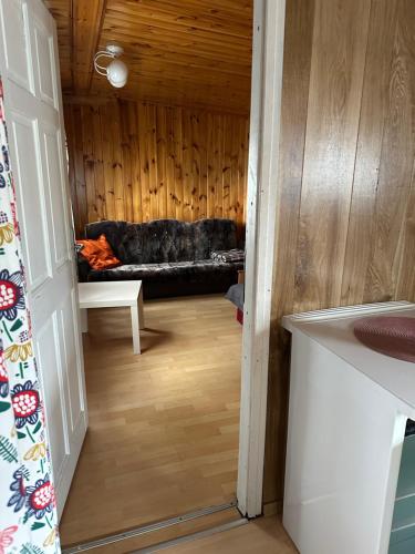 a hallway with a couch in a room with wooden walls at Domki ALKANA - domek 3 in Nowęcin