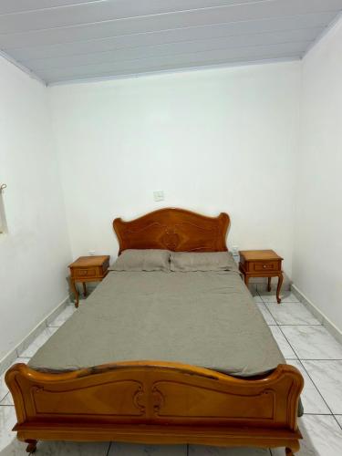 a bedroom with a wooden bed with two night stands at Casa central, com 2 quartos e até 2 carros in Divinópolis