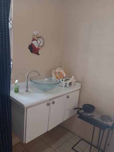 a bathroom with a sink and a clock on the wall at Studio comodo con aire acondicionado in Caguas