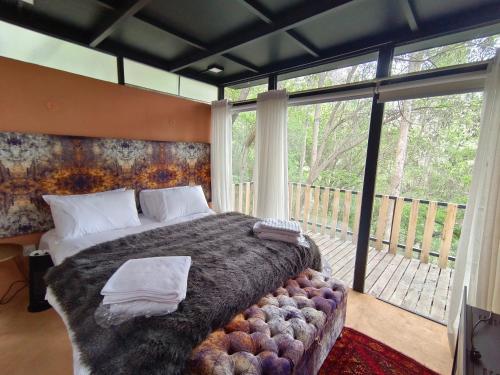 a bedroom with a large bed and a large window at Cloud Nine And A Half in Hunza Valley