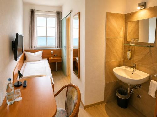 a hotel room with a bed and a sink at Hotel Seerose in Wilhelmshaven