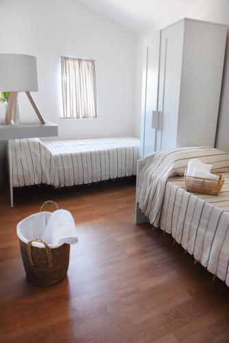 a room with two beds and a basket of towels at Casa Nora in Valsinni