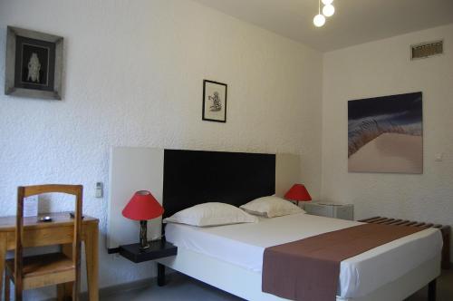 a bedroom with a bed and a table and a chair at Maison d'hôtes Opanoramic in Dakar