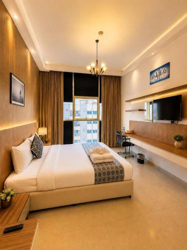 a bedroom with a large bed and a desk at The Saj Hotel Apartments in Ras al Khaimah
