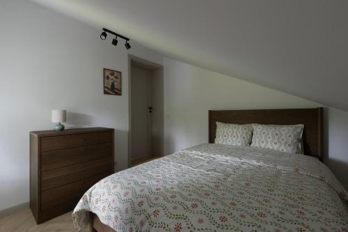 a bedroom with a bed and a wooden dresser at Leśne Chwile in Osiek