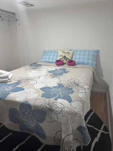 a bedroom with a bed with a blue and white comforter at Cozy Broadway in Minneapolis