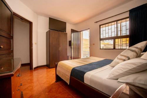 a bedroom with a large bed and a window at Hotel Rivera Plaza in Cali