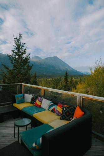 a balcony with two couches and a view of a mountain at CabinsOver Crag Lake Glamping Bear in Carcross