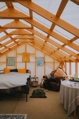 a room with two beds in a room with wooden ceilings at CabinsOver Crag Lake Glamping Bear in Carcross