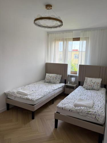 a bedroom with two beds and a window at Apartament Opoczno in Opoczno