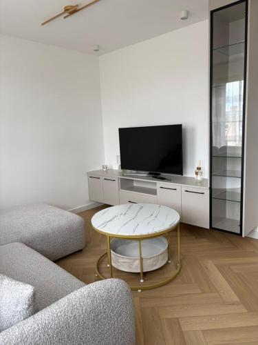 a living room with a tv and a coffee table at Apartament Opoczno in Opoczno