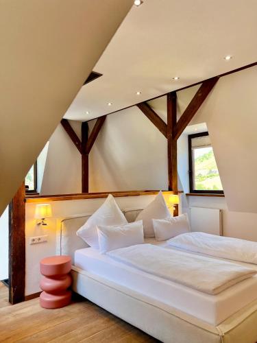 a white bed in a room with wooden ceilings at Hotel Villa Vie Cochem in Cochem