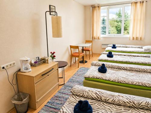 a hotel room with three beds and a table at Paide Event Center Hostel in Prääma
