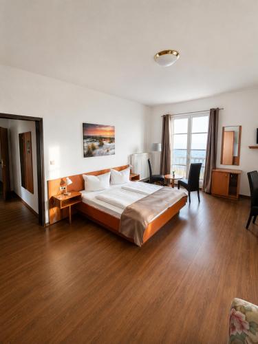 a hotel room with a large bed and a desk at Hotel Seerose in Wilhelmshaven
