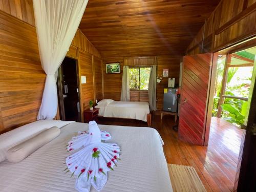 a bedroom with two beds with an umbrella on it at Cabañas Los Laguitos Rio Celeste in El Achiote