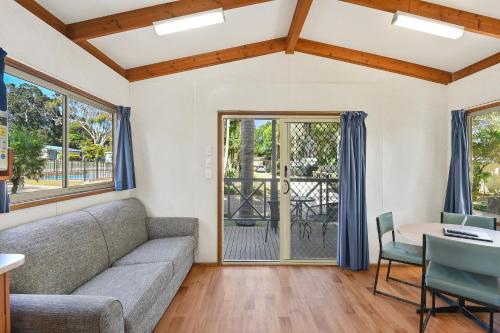 a living room with a couch and a table at Flynns Beach Caravan Park in Port Macquarie