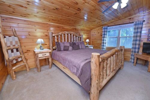 a bedroom with a bed in a log cabin at S'more Waggin' Cabin: Pet-Friendly--wifi, firepit, pool table in Blue Ridge
