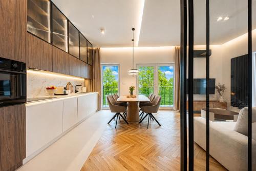 a kitchen and living room with a table and chairs at Porto Marina - widok na jezioro z każdego z 3 pokoi, lux, garaż, klima in Iława