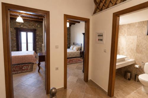 a bathroom with a toilet and a bedroom at Althaia in Ano Chora