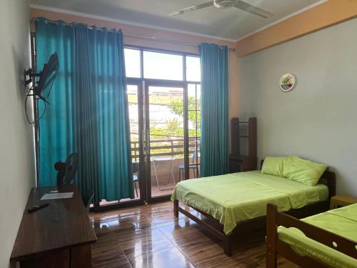 a bedroom with two beds and a large window at Heliconia's Inn in Puerto Maldonado