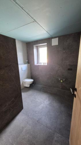 an empty bathroom with a toilet and a window at Hof am Berg in Kaunerberg