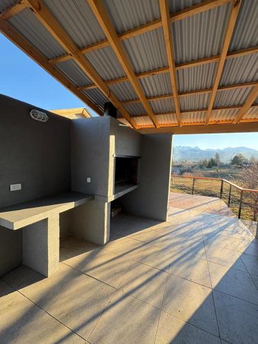 a patio with a bench under a roof at Complejo Aiken in Trevelín