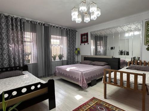 a bedroom with two beds and a chandelier at Dream Guest House in Bosteri