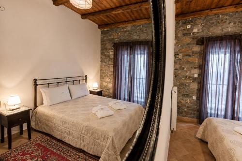 a bedroom with a bed and a mirror at Althaia in Ano Chora