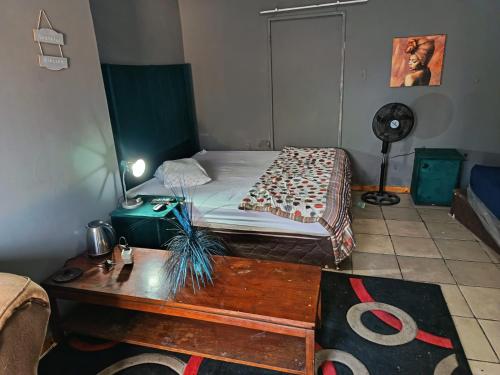 a bedroom with a bed with a table and a table at Potch Guest Home in Potchefstroom