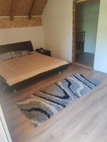 a bedroom with a bed with a mirror and a rug at Green Escape in Zavidovići