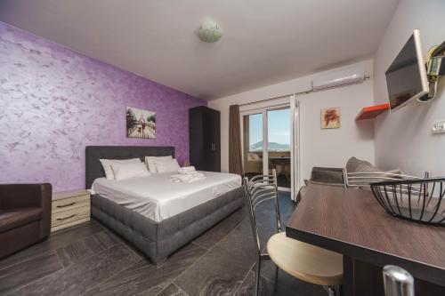 a bedroom with a bed and a purple wall at Alessandra Apartments & free private parking in Sveti Stefan