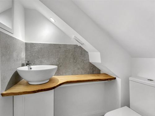 a bathroom with a white sink on a wooden shelf at Oxford House Porlock in Porlock