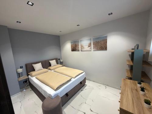 a bedroom with a bed and a wooden table at Guest Apartman in Tiszakécske
