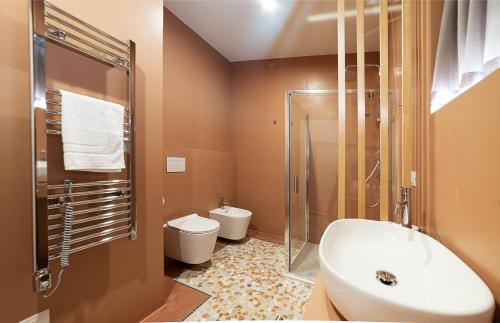 a bathroom with a sink and a shower and a toilet at Foresteria Pian di Spagna 2 in Dubino