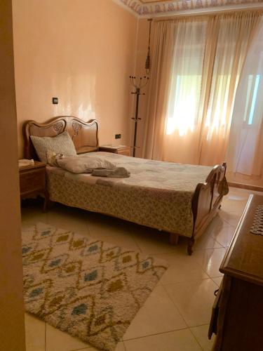 a bedroom with a bed and a window and a rug at Rayan in Tangier