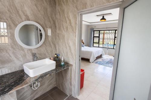 a bathroom with a sink and a mirror at Chic Modern Escape in Lusaka
