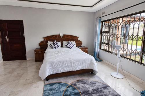 a bedroom with a bed and a large window at Chic Modern Escape in Lusaka