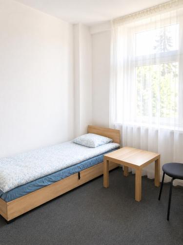 a bedroom with a bed and a table and a window at Rooms Gdynia Orłowo in Gdynia