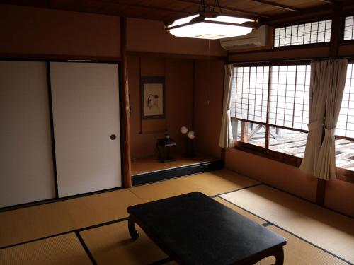 a room with a table and a door and windows at 卌屋 shioya in Gujo