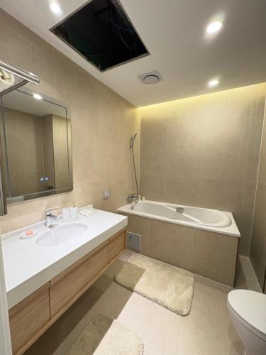 a bathroom with a sink and a tub and a toilet at Mandala 365 Residential Tower in Ulaanbaatar