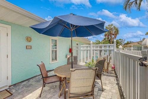 a patio with a table with a blue umbrella at Sea Pirate 1 in Holmes Beach