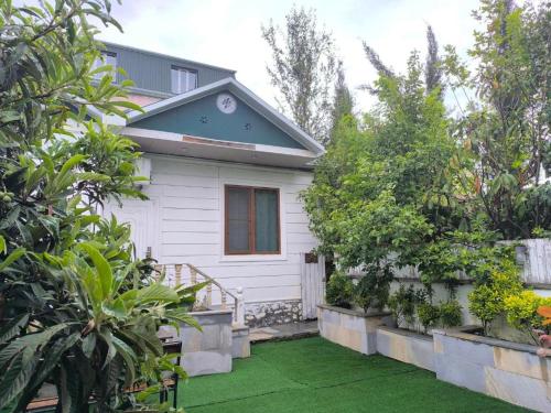 a white house with a garden in front of it at Fortuna Gabala Boutique Hotel & Restaurant in Gabala